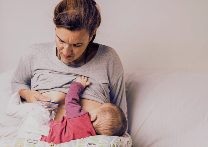 picture of a woman struggling to breastfeed her baby