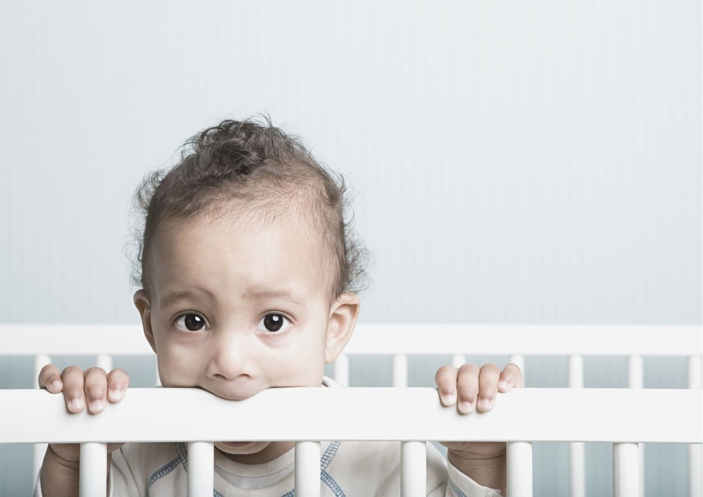 picture of a sad baby in a cot