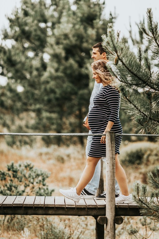 Pregnant couple walking on a bridge