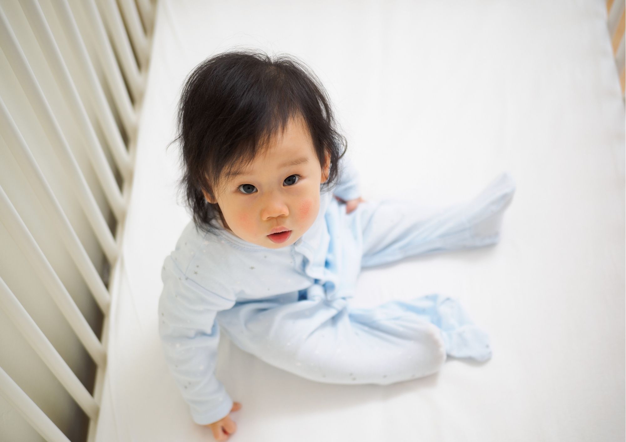 picture of a baby awake in cot sleep regression