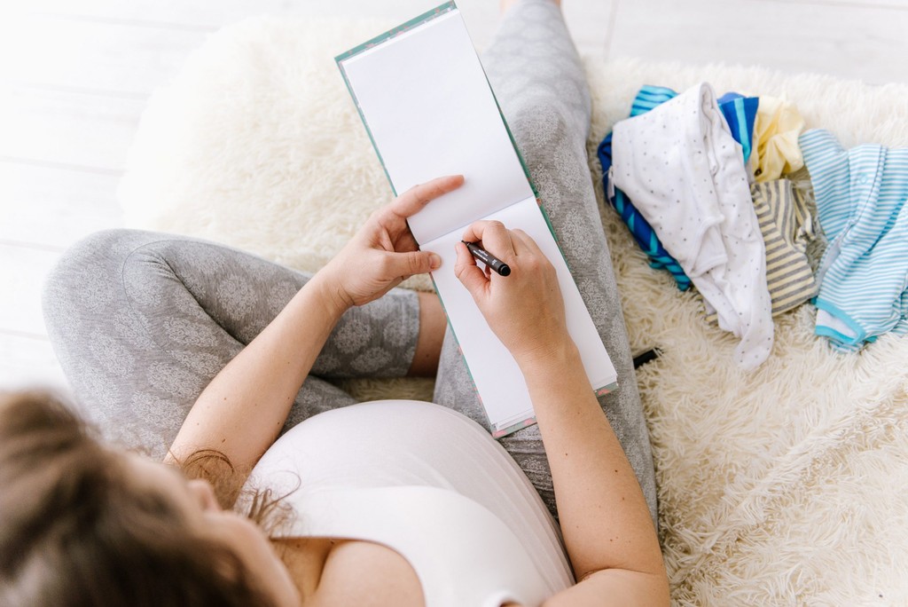 a pregnant woman writing a list