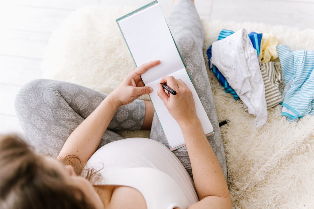 a pregnant woman writing a list