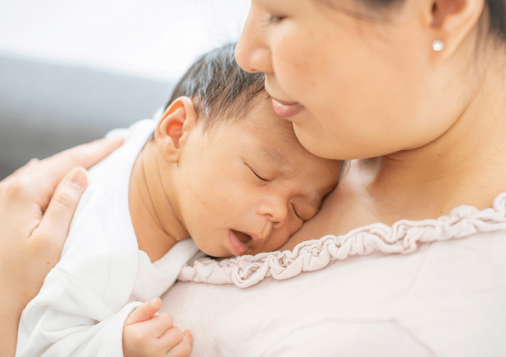 picture of tired mother holding newborn